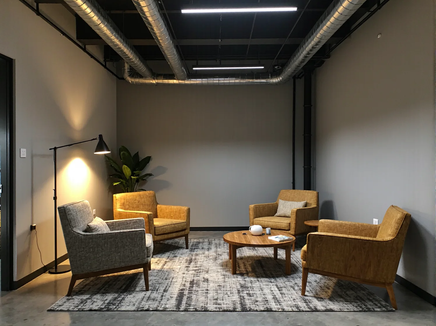 Wspólna strefa pracy w stylu loftowym z drewnianymi regałami i ergonomicznymi fotelami biurowymi.